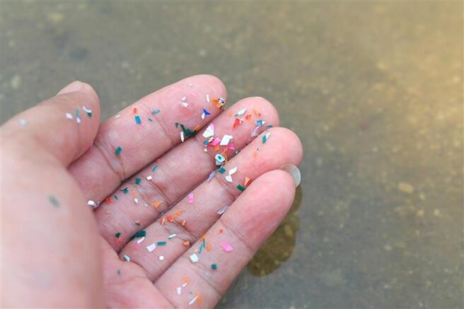 Hånd med plastpartikler