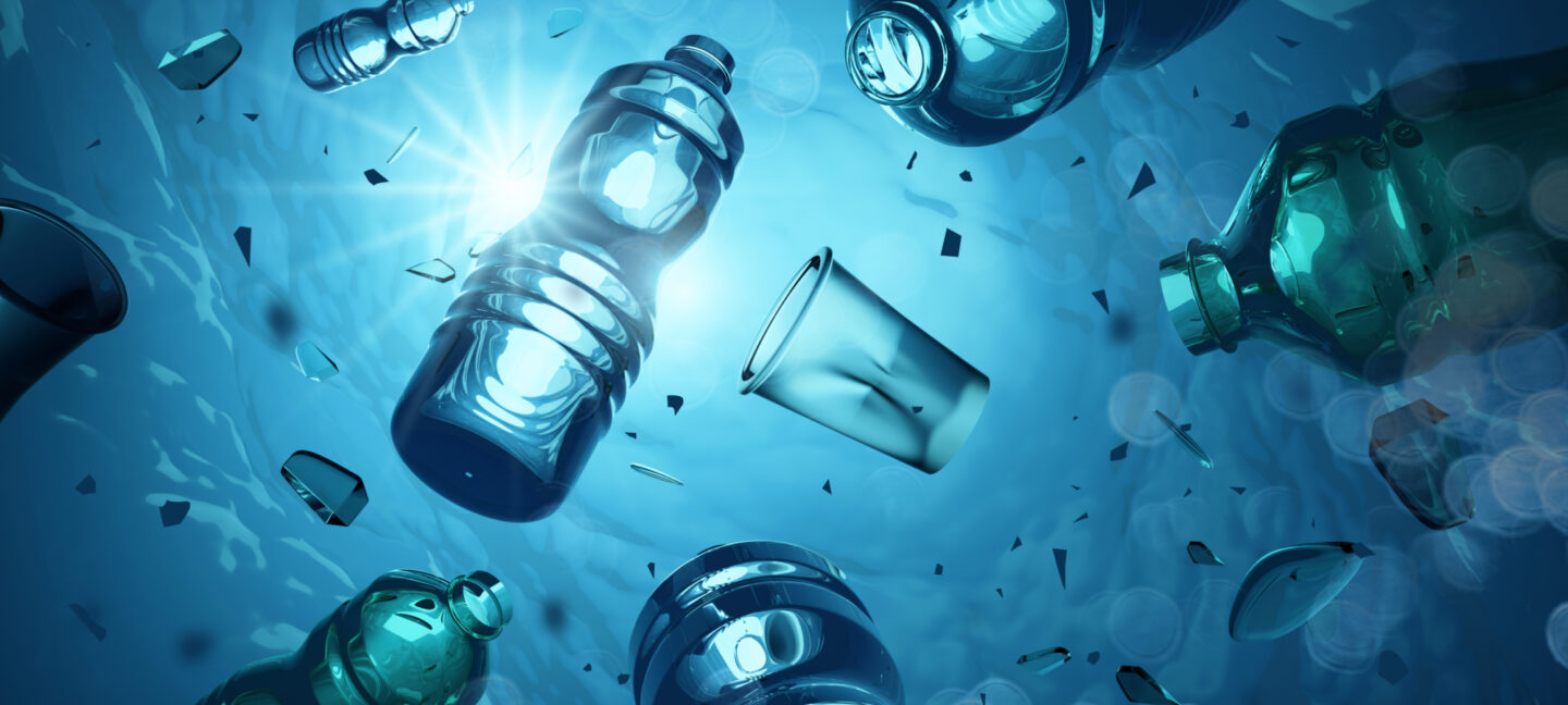 Plastflasker og kopper som flyter i havet sett undenifra