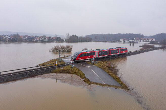 Tog kjører i et oversvømt landskap