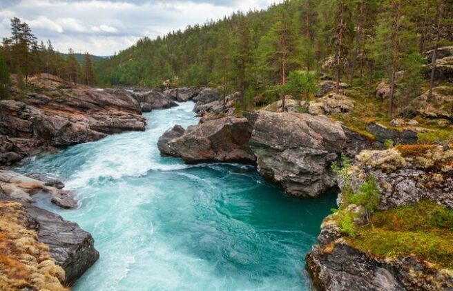 Bilde av Sjoa, en vakker turkisblå elv om renner gjennom et vilt landskap.