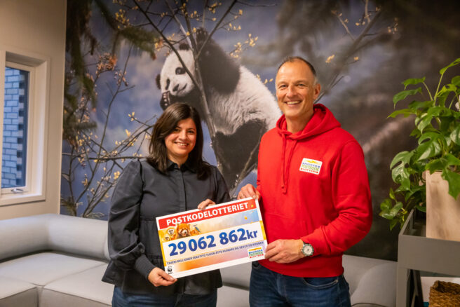 Generalsekretær i WWF Karoline Andaur sammen med Tom Stiansen fra Postkodelotteriet. Karoline holder en stor sjekk og begge smiler.